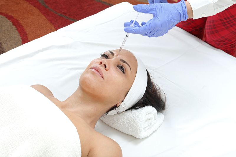 Woman Having Forehead Injection Filler Treatment at Clinic
